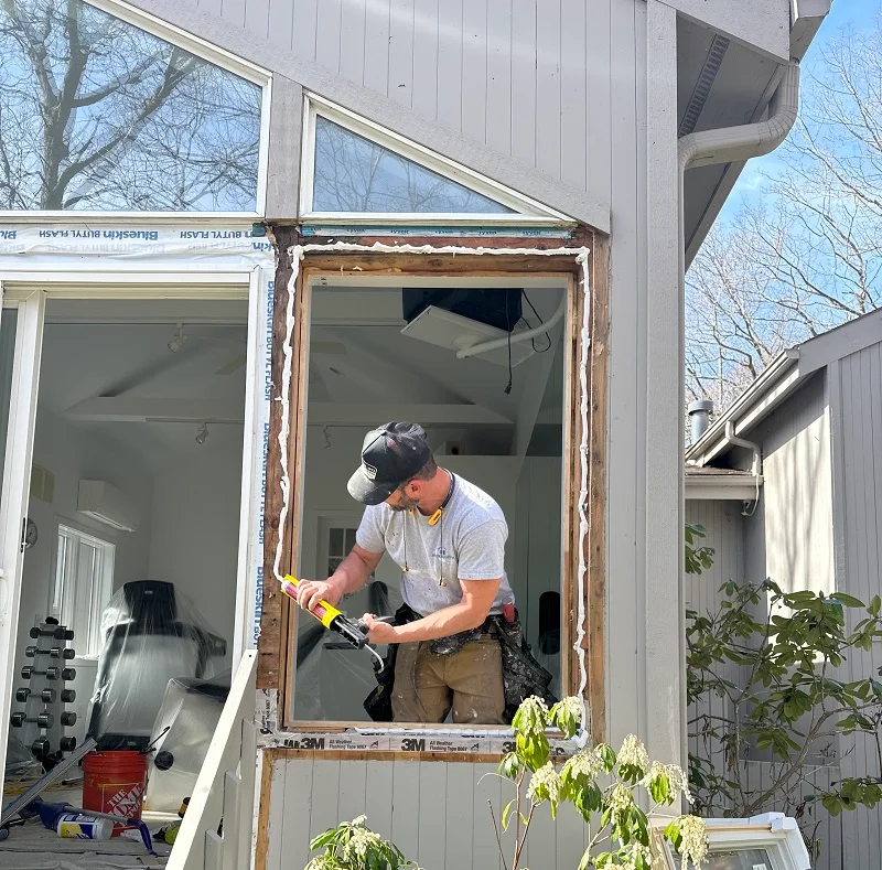 Window Solutions Plus master installer applying sealant before casement window installation